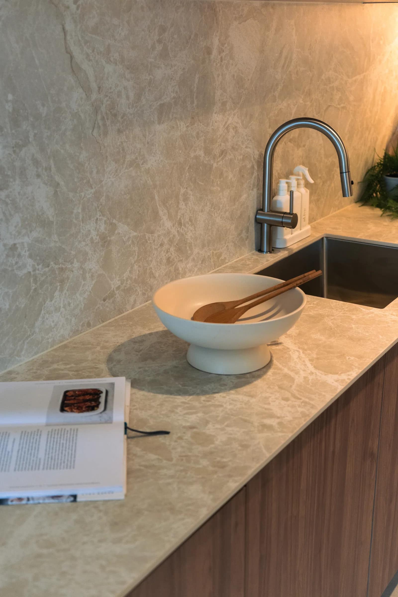 Kitchen bench detail in the completed residence: the Lusso Stone top, stone splashback, undermount sink and satin tapware